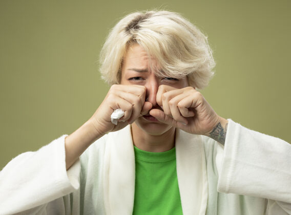 头发有病的不健康的短发妇女感到不适不安揉眼睛患流感流鼻涕站在灯光背景下流涕不适生病