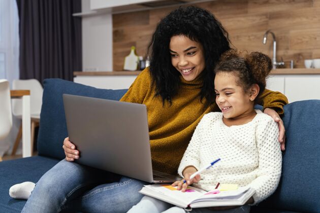笔记本电脑笑脸少女帮妹妹上网上学青少年年轻课程
