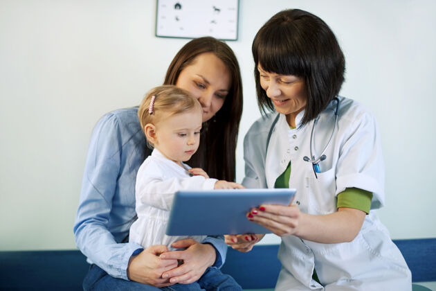 职业医生在平板电脑上显示母亲的医疗结果女儿制服护理