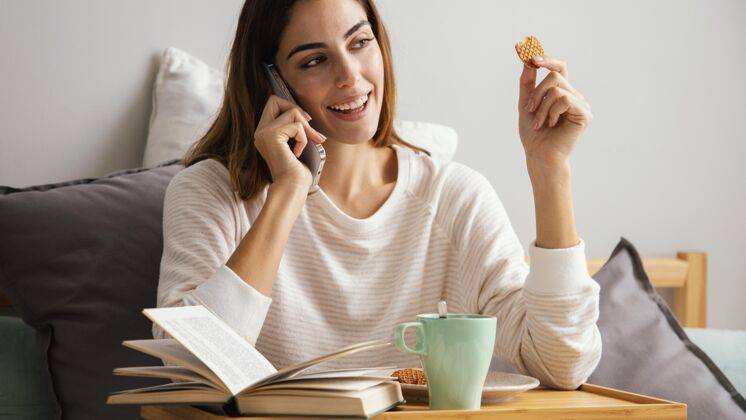 女性在家里吃早餐和打电话的女人家庭休息时间休假