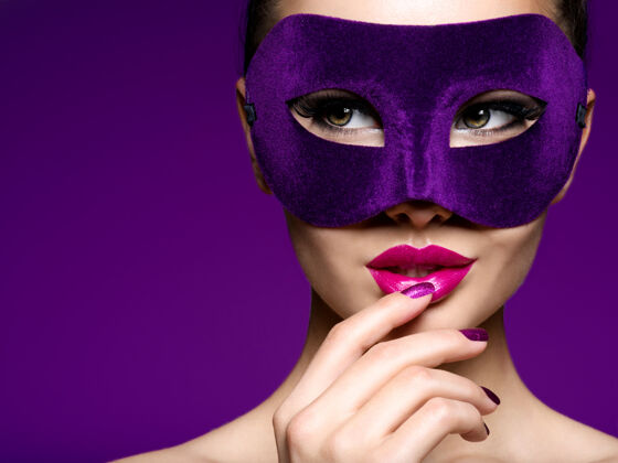 时尚一个漂亮女人的肖像 紫色的指甲 脸上戴着紫色的戏剧面具模特魅力美丽