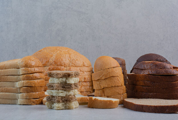 切片新鲜的白色和棕色面包片放在大理石背景上新鲜棕色白色
