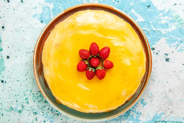 糖浆俯瞰美味的蛋糕 黄色糖浆和红色草莓放在蓝色表面饼干蛋糕烤甜饼糖茶饼干新鲜烘焙