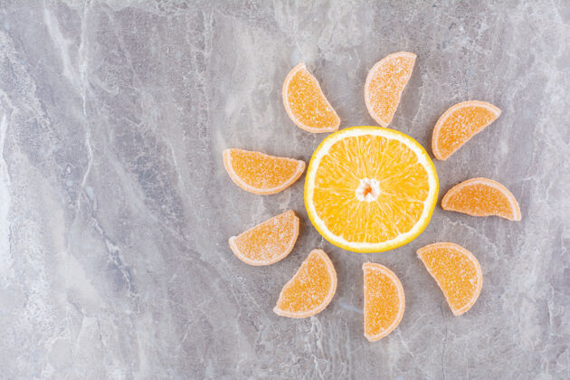 果酱新鲜的橘子片和甜甜的果酱放在大理石背景上美味糖糖果