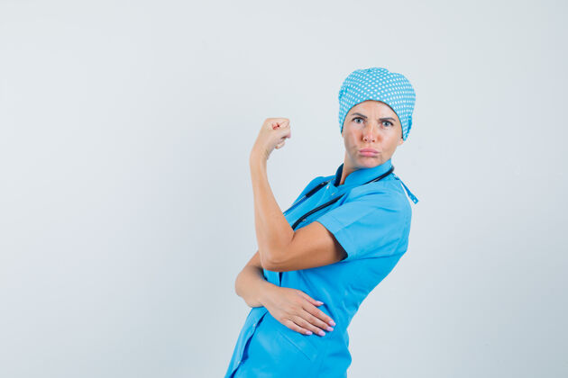 女人身着蓝色制服的女医生展示手臂肌肉 看上去很自信肖像肌肉实验室