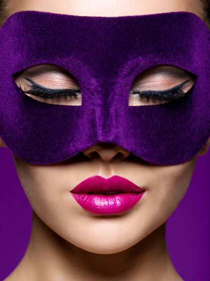 模特脸上戴着紫色戏剧面具 嘴唇是紫色的女人时尚年轻漂亮