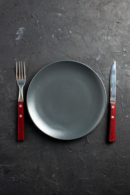黑色盘子俯视图黑色表面上的黑色板叉和刀叉子视图薯条