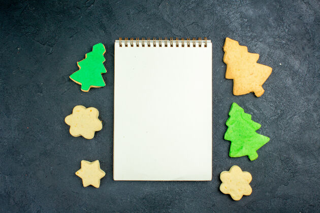 黑板顶视图笔记本圣诞饼干在黑暗的表面空白国家视图
