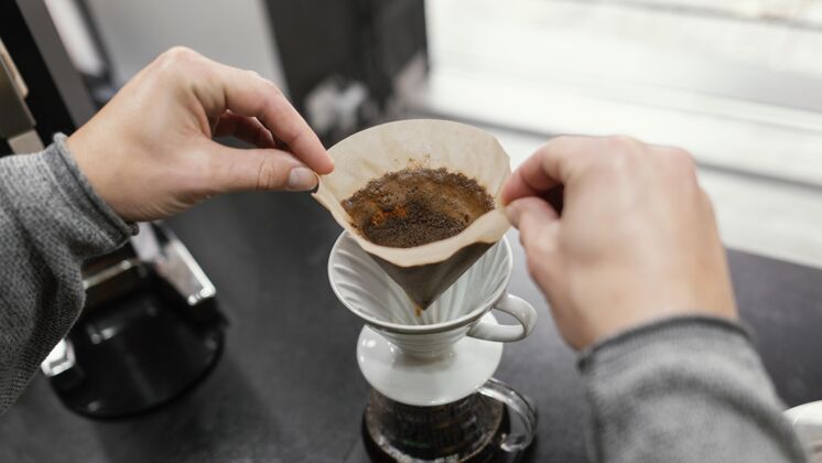 雇员高角度男咖啡师取下咖啡过滤器咖啡店男性服务员