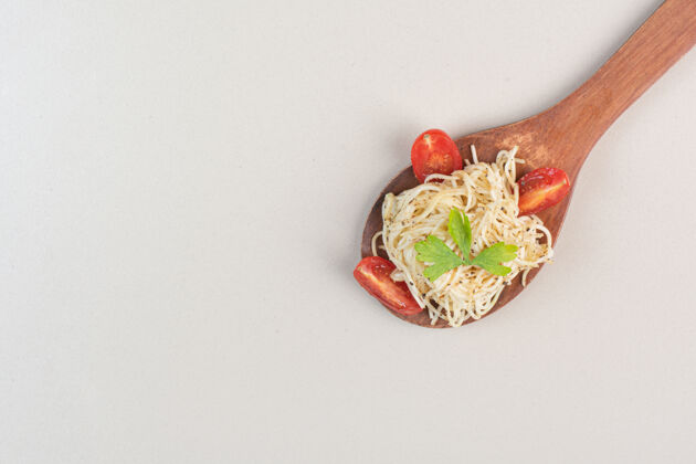 意大利面汤匙意大利面 番茄片和欧芹放在白色表面意大利面食物蔬菜