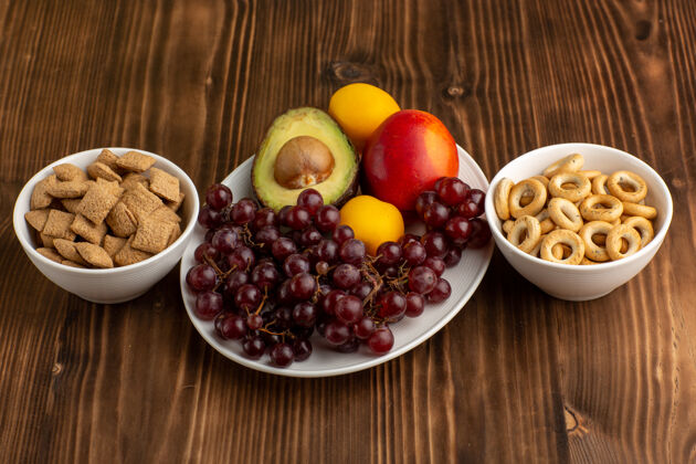 健康正面图新鲜水果葡萄芒果鳄梨和葡萄柚饼干放在棕色的桌子上葡萄柚胡椒醇香