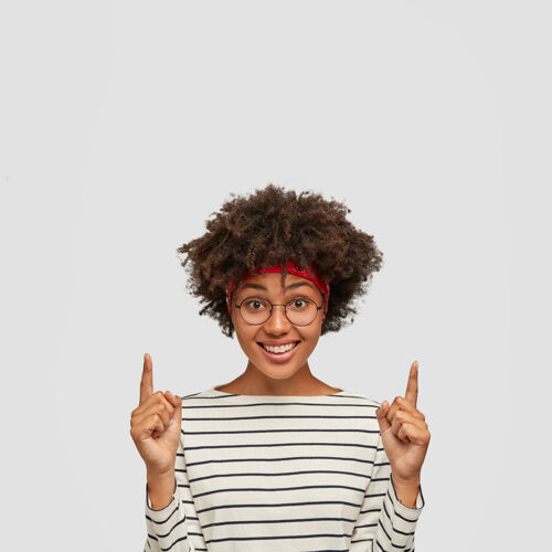 食指积极的黑皮肤女性与非洲发型垂直广告眼镜