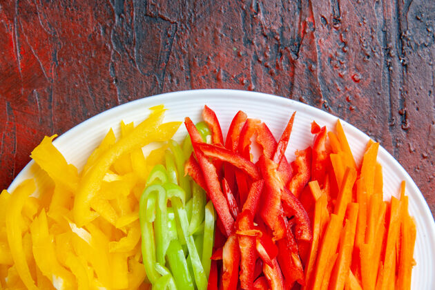 蔬菜上半部分查看彩色切辣椒在白色盘子上暗红色的表美食辣椒景观