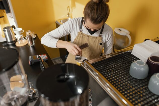 就业戴着面具在咖啡馆工作的女咖啡师工作咖啡店服务员