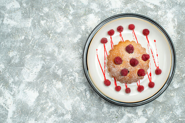 Berrycake顶视图浆果蛋糕白色椭圆形板上的灰色表面复制空间面粉甜点顶