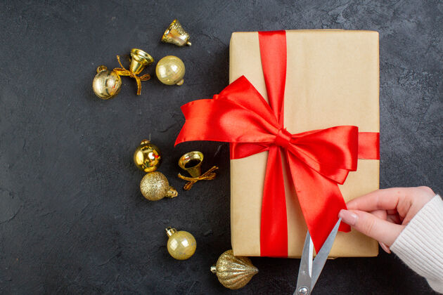 圣诞节上图为黑色背景上的礼品盒和装饰配件上手工切割的红丝带剪头发幻灯片蝴蝶结