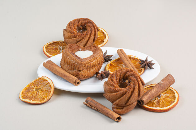 水果美味的蛋糕 橘子片 丁香和肉桂放在白色盘子里美味蛋糕丁香