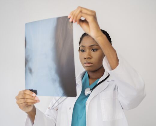 援助中景医生在看X光片职业医生卫生工作者