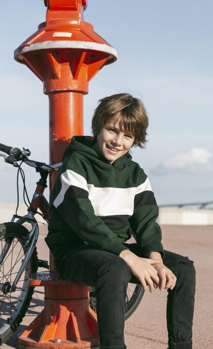 青年那个男孩骑着自行车在户外的望远镜旁摆姿势活动自行车户外