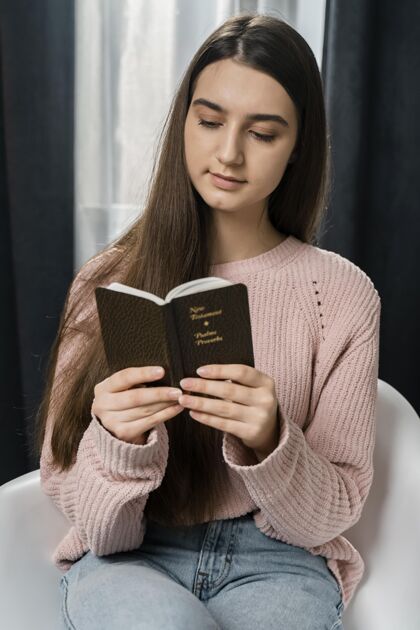 祈祷坐在椅子上读圣经的女人圣洁宗教圣经