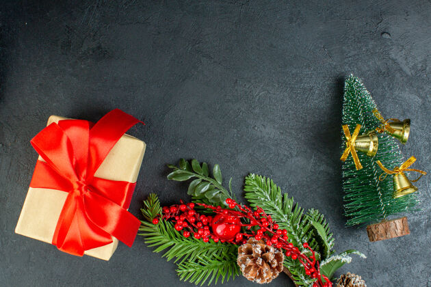 花束礼品盒上方视图 黑色背景上有蝴蝶结形状的红丝带 冷杉树枝 针叶树 圆锥形圣诞树礼品盒蝴蝶结圣诞