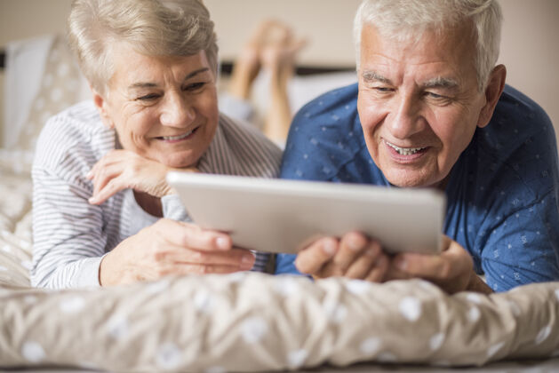 新鲜祖父母一边休息一边使用数码平板电脑祖父丈夫妻子