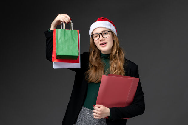 包装正面图：年轻女性 深色地板上有包装 新年礼物 圣诞礼物购物漂亮年轻女性