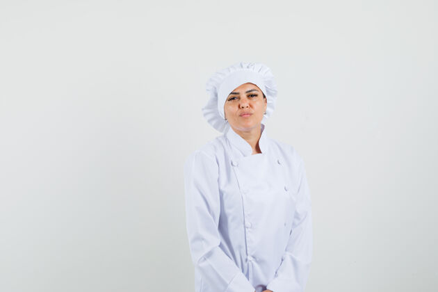 举行身着白色制服的女厨师看着镜头 神情自信工人新鲜烹饪
