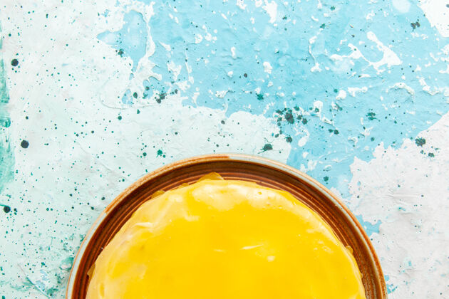 糖浆顶部近距离观看美味的蛋糕与黄色糖浆在蓝色的表面蛋糕糖饼干