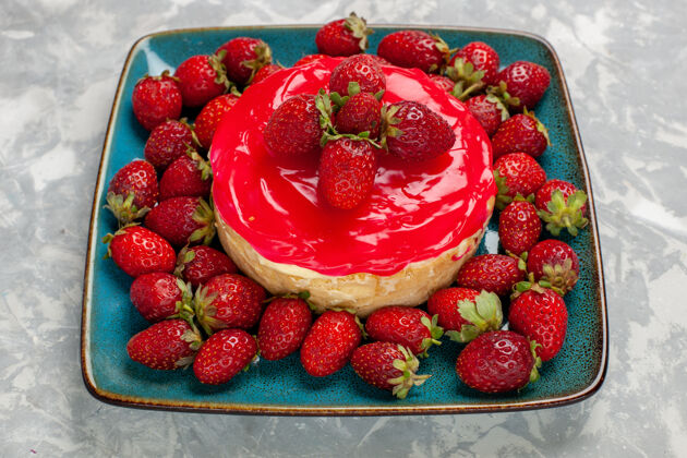前面的前视图美味的蛋糕小馅饼与红色奶油和新鲜草莓浅白色的表面蛋糕水果小的