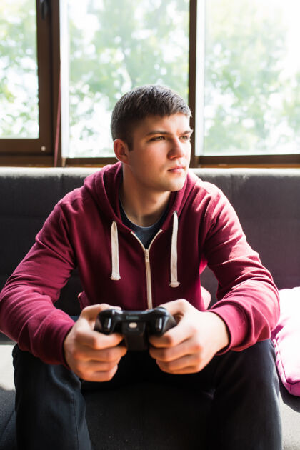 电脑快乐的年轻人在周末欢笑和玩电子游戏视频年轻男人