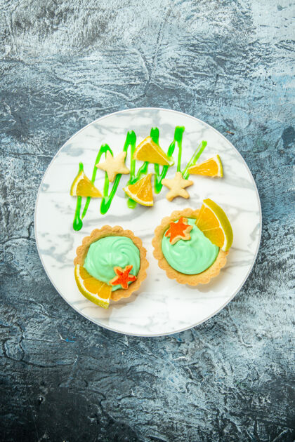 切片顶视图小馅饼与绿色糕点奶油和柠檬片在黑暗的桌子上免费的地方盘子美食食物奶油