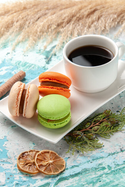 食物正面是法国马卡龙 蓝色表面有一杯茶饮料杯子咖啡