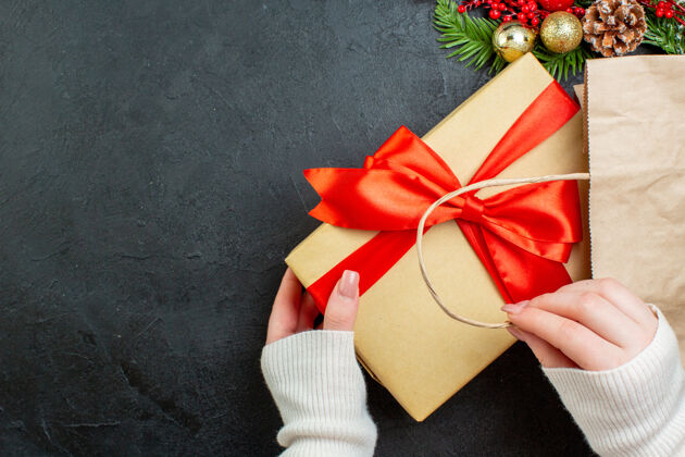 蝴蝶结上图中的手拿着一个漂亮的礼品盒在黑暗的背景下圣诞节风景礼盒