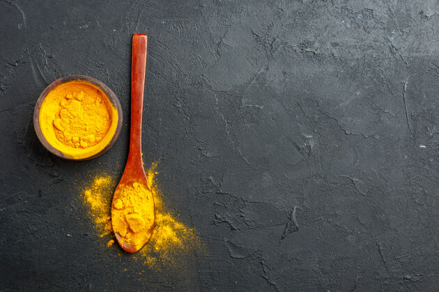 木头顶视图姜黄碗姜黄在黑暗的桌子上的木勺与自由空间姜黄姜黄碗棍子