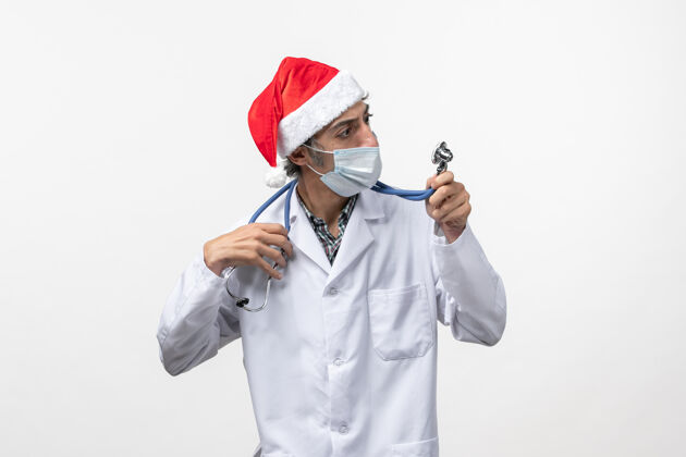 视图正面图：戴着口罩的男医生在白墙假日大流行病毒男人护士医生