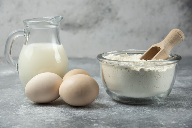 面粉大理石桌上放着一碗面粉 鸡蛋和牛奶做的厨房鸡蛋