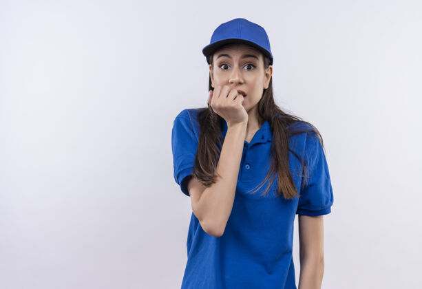 站立穿着蓝色制服 戴着帽子的年轻女送货员紧张得咬指甲指甲帽子压力