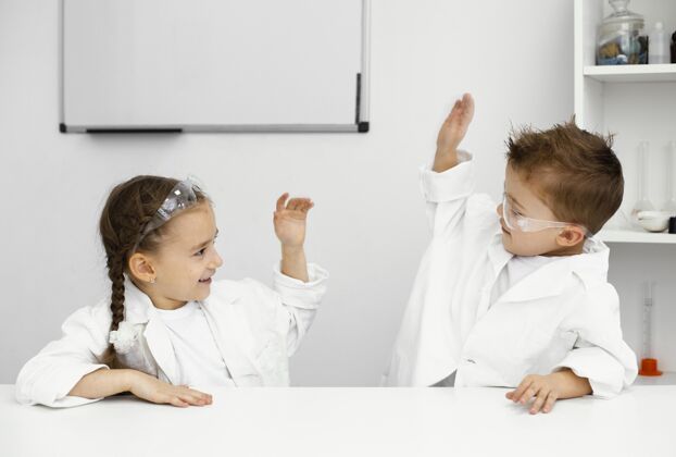 实验室年轻的儿童科学家们在做实验和互相击掌时玩得很开心水平安全眼镜学习