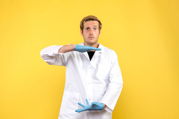 医学正面图黄色背景上的年轻男医生人类医学病毒-大流行西装医生帅哥