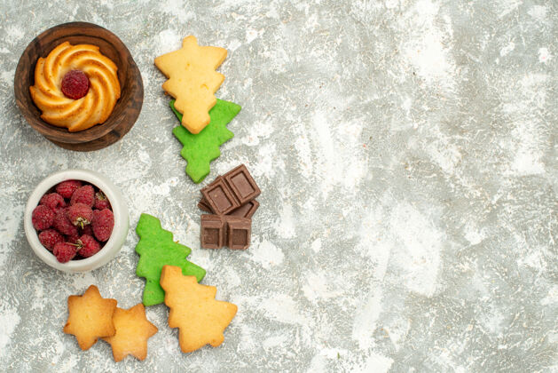 食物顶视图圣诞树饼干饼干在碗里与树莓巧克力在灰色的桌子上免费空间甜点饼干饼干