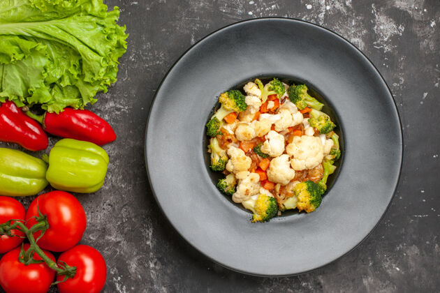 沙拉俯视图西兰花和花椰菜沙拉西红柿绿色和红色甜椒莴苣在黑暗的表面午餐晚餐铃铛