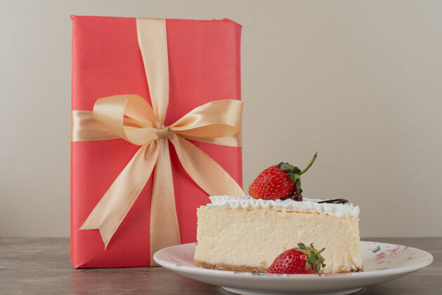 奶油草莓芝士蛋糕和大理石桌上的礼物礼物甜点丝带