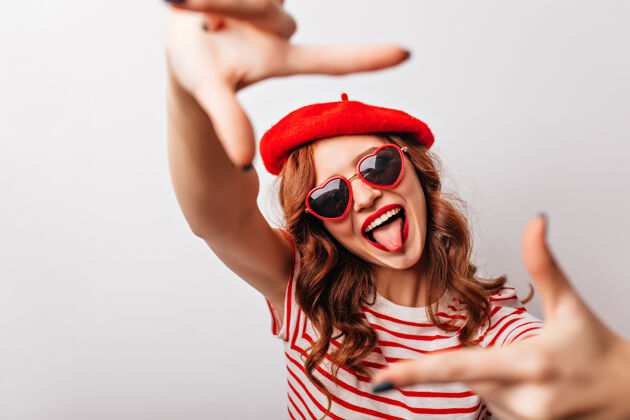 红发迷人的法国女人戴着太阳镜笑时尚的卷发姜汁女孩在白墙上鬼混休闲Swoosh时尚