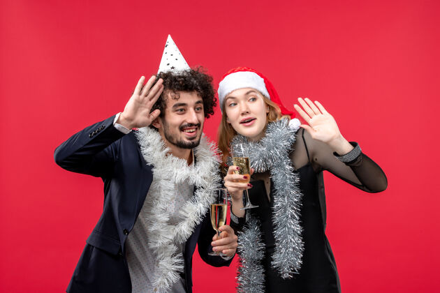 肖像正面图年轻幸福的夫妇在红地板上庆祝新年照片圣诞爱情风景服饰美丽