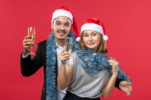 圣诞节前视图年轻夫妇刚刚庆祝新年在红墙党爱圣诞节年轻夫妇帽子庆祝