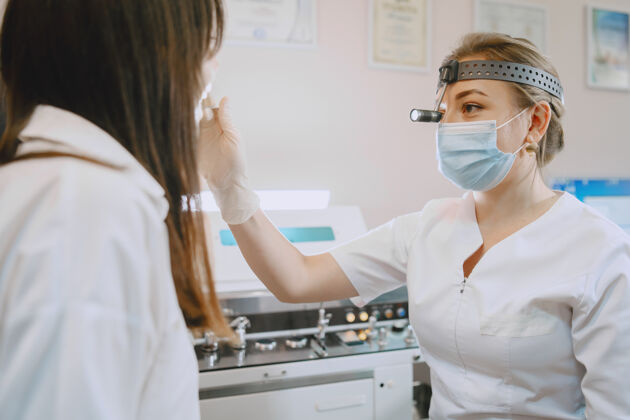 组织医务室的女病人戴着医用面罩的医生医务人员专业人员治疗