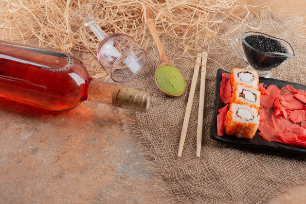 勺子一瓶葡萄酒 酒杯和寿司放在粗麻布上液体寿司绳子