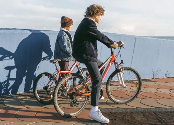 乐趣孩子们一起在户外骑自行车的侧视图爱好自行车青年