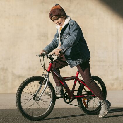 年轻孩子在户外骑自行车玩的侧视图活动爱好户外